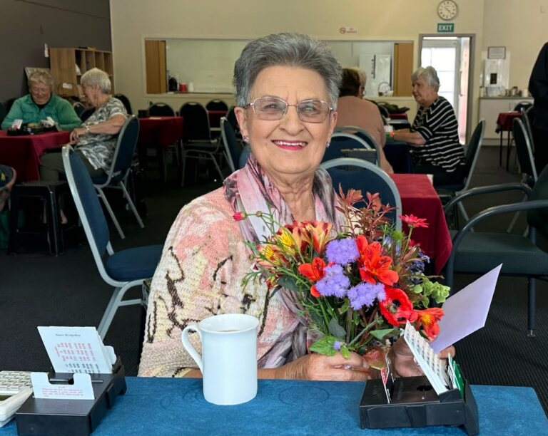 A member at the bridge table with a bouquet of flowers